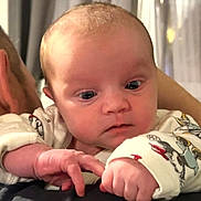 Jade participe au concours pour gagner de l'argent avec cette photo : baby, infant, child, person, face, hand, onesie, cartoon_print, indoor, curious, close_up, parent, shoulder, skin, expression, young, cute, warm, soft_light, portrait