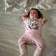 Eliya a rejoint le concours — aidez-le/la à gagner de superbes lots ! baby, bed, cartoon_print, child, cozy, cute, face, indoors, infant, pajamas, person, pink_clothing, portrait, relaxed, resting, sleeping, socks, soft_lighting, white_bedspread, young_child
