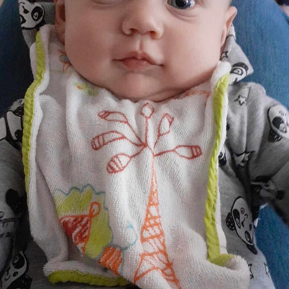 Gabin participe au concours pour gagner de l'argent avec cette photo : apparel, baby, bib, bottle, child, childcare, clothing, cute, expression, eyes, face, feeding, indoor, infant, onesie, panda_print, person, portrait, seated, young