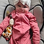 baby, infant, child, pink_clothing, headband, white_bow, smile, plush_toy, giraffe_toy, baby_chair, cushion, cute, indoors, portrait, person, soft_toy, seated, cozy, happy, young_child