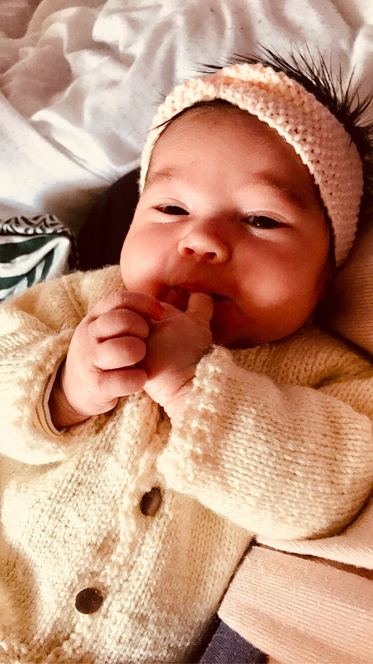 Amélia participe au concours pour gagner de l'argent avec cette photo : baby, baby_toddler_clothing, cheek, chin, comfort, eye, eyebrow, eyelash, finger, gesture, happy, head, lip, mouth, nose, person, skin, sleeve, smile, thumb