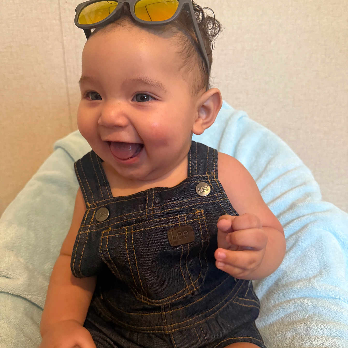 Dante Valentin joined the competition — help win amazing prizes! baby, bright_eyes, child, clothing, curly_hair, cute, denim_overalls, face, happy, indoor, infant, joyful, light_blue_blanket, person, portrait, sitting, small_hand, smile, sunglasses, young