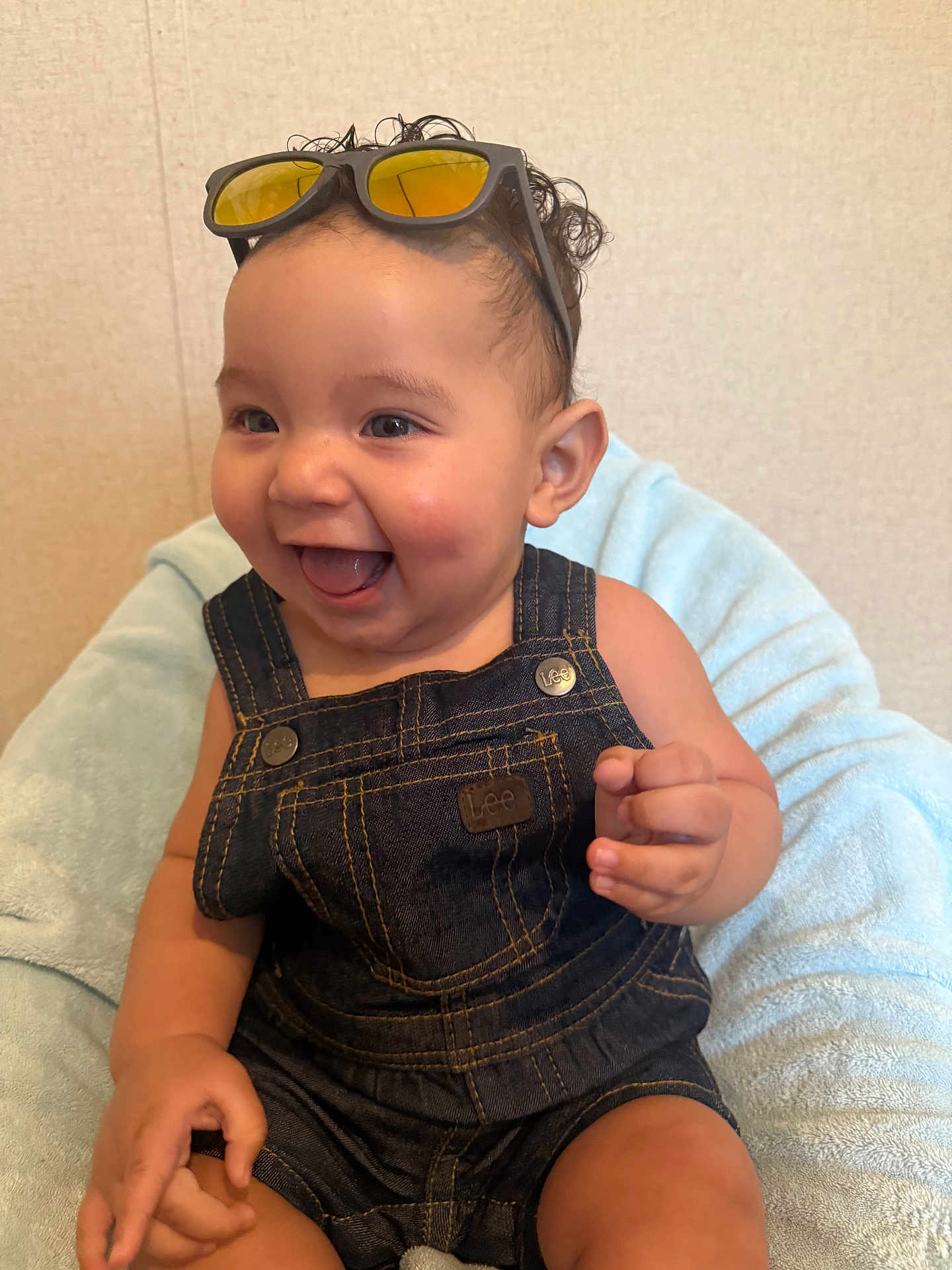 Dante Valentin joined the competition — help win amazing prizes! baby, bright_eyes, child, clothing, curly_hair, cute, denim_overalls, face, happy, indoor, infant, joyful, light_blue_blanket, person, portrait, sitting, small_hand, smile, sunglasses, young