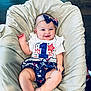 baby, child, smiling, headband, bow, cushion, clothing, patterned_clothing, stars, stripes, floor, wooden_floor, sitting, cute, infant, posing, indoors, comfort, happy, portrait