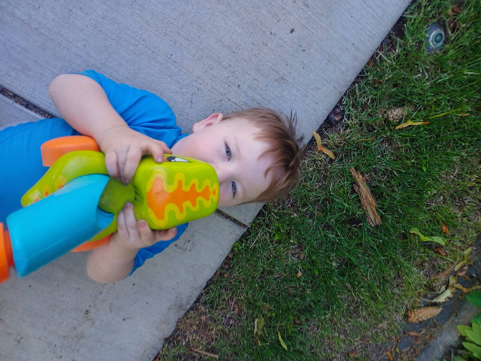 Ashton is registered to the contest to win money with this photo: asphalt, baby, baby_products, baby_toddler_clothing, baby_toys, child, flooring, fun, grass, groundcover, leisure, people_in_nature, person, plastic, plastic_bottle, play, recreation, road_surface, sitting, toddler