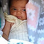baby, infant, blanket, clothing, face, eyes, drool, soft_texture, pattern, cute, young_child, child, newborn, portrait, wrapped, snug, comfort, warm, indoors, resting