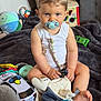 Maëlio participe au concours pour gagner de l'argent avec cette photo : toddler, child, pacifier, toy_car, blanket, soft_toy, indoor, sitting, curious, cute, basket, colorful, clothing, foot, face, playroom, furniture, toy, young_child, comfort