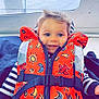 toddler, child, life_jacket, orange, smiling, boat, window, sky, blue_eyes, striped_shirt, happy, young_child, safety, clothing, seat, indoor, portrait, casual, cute, playful