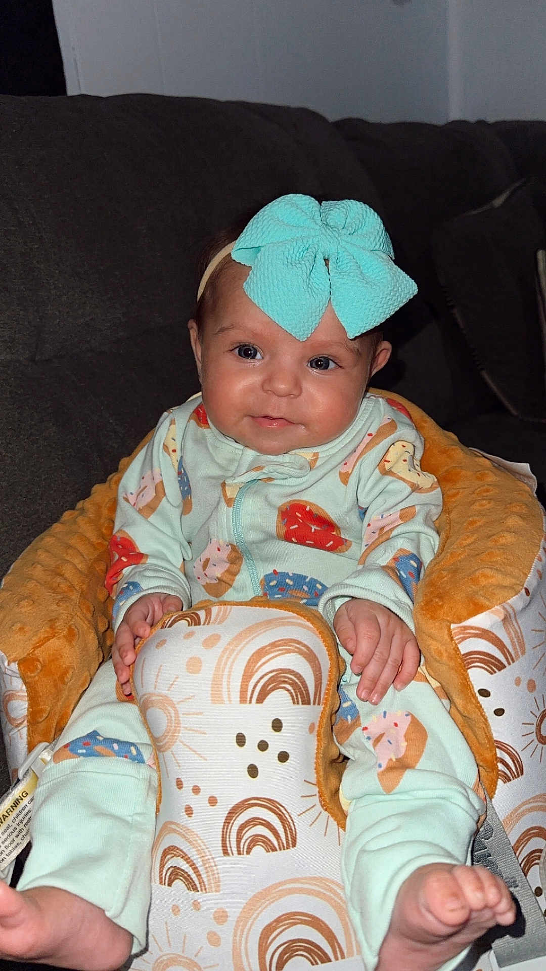 Haisley joined the competition — help win amazing prizes! baby, infant, child, onesie, headband, bow, seat, baby_seat, couch, pattern, donut_pattern, rainbow_pattern, sun_pattern, hand, foot, face, eyes, cheeks, happy, indoor