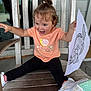 child, clothing, cute, drawing, fish, happy, indoor, joyful, leggings, paper, playful, pony_tail, portrait, shoes, sitting, smiling, toddler, tshirt, wood, wooden_chair