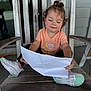 Athena joined the competition — help win amazing prizes! black_pants, calm, casual_clothing, child, curly_hair, cute, daylight, focused, outdoor, paper, peach_tshirt, porch, relaxed, sitting, small_ears, snail_graphic, sneakers, toddler, wooden_chair, wooden_floor