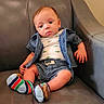 baby, child, infant, sitting, armchair, leather, portrait, face, eyes, hair, clothing, striped_clothes, shorts, shirt, socks, colorful, indoor, furniture, serious, photography
