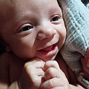Alaric is registered to the contest to win money with this photo: baby, infant, child, smiling, happy, face, portrait, close_up, indoor, blanket, cozy, hands, fists, eyes, mouth, hair, head, cuddled, soft_lighting, family_photo