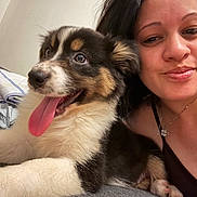 Nala participe au concours pour gagner de l'argent avec cette photo : black_hair, closeup, companion, couch, cute, dog, friendship, fur, happy, indoor, laying, mammal, necklace, pet, portrait, puppy, relaxing, smile, tongue_out, woman