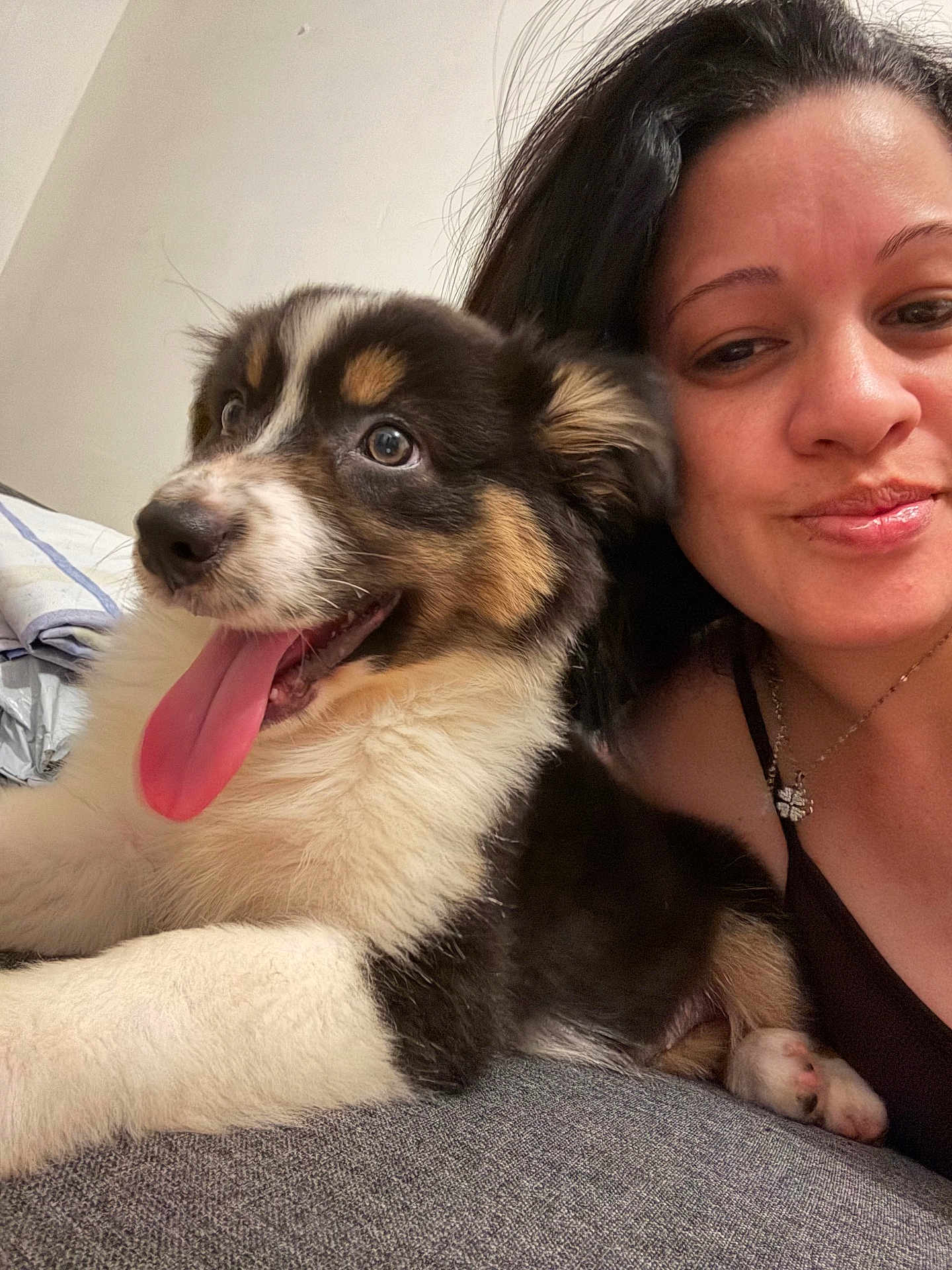Nala participe au concours pour gagner de l'argent avec cette photo : black_hair, closeup, companion, couch, cute, dog, friendship, fur, happy, indoor, laying, mammal, necklace, pet, portrait, puppy, relaxing, smile, tongue_out, woman