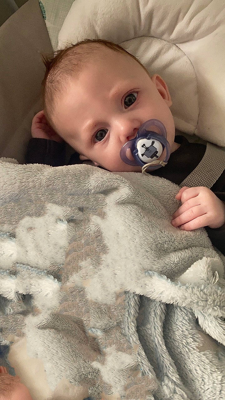 Cason is registered to the contest to win money with this photo: baby, baby_toddler_clothing, cheek, child, comfort, ear, eye, eyebrow, eyelash, flooring, grey, iris, linens, mouth, neck, nose, person, skin, sleeve, textile