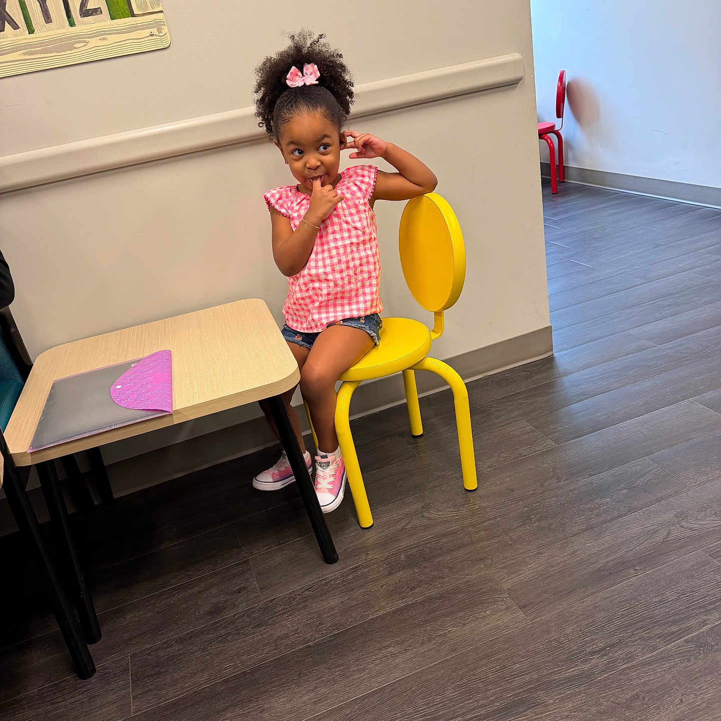 Antonella joined the competition — help win amazing prizes! child, girl, yellow_chair, pink_shirt, bow, table, floor, indoor, wood_floor, sneakers, curly_hair, playful, seated, wall, painting, furniture, mischievous, casual_clothing, small_chair, room