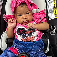 Journey joined the competition — help win amazing prizes! baby, child, car_seat, pink_clothing, headwrap, heart_pattern, infant, cute, portrait, strapped_in, seatbelt, denim_print, colorful, young_child, baby_girl, sitting, close_up, indoors, serious_expression, small_hands