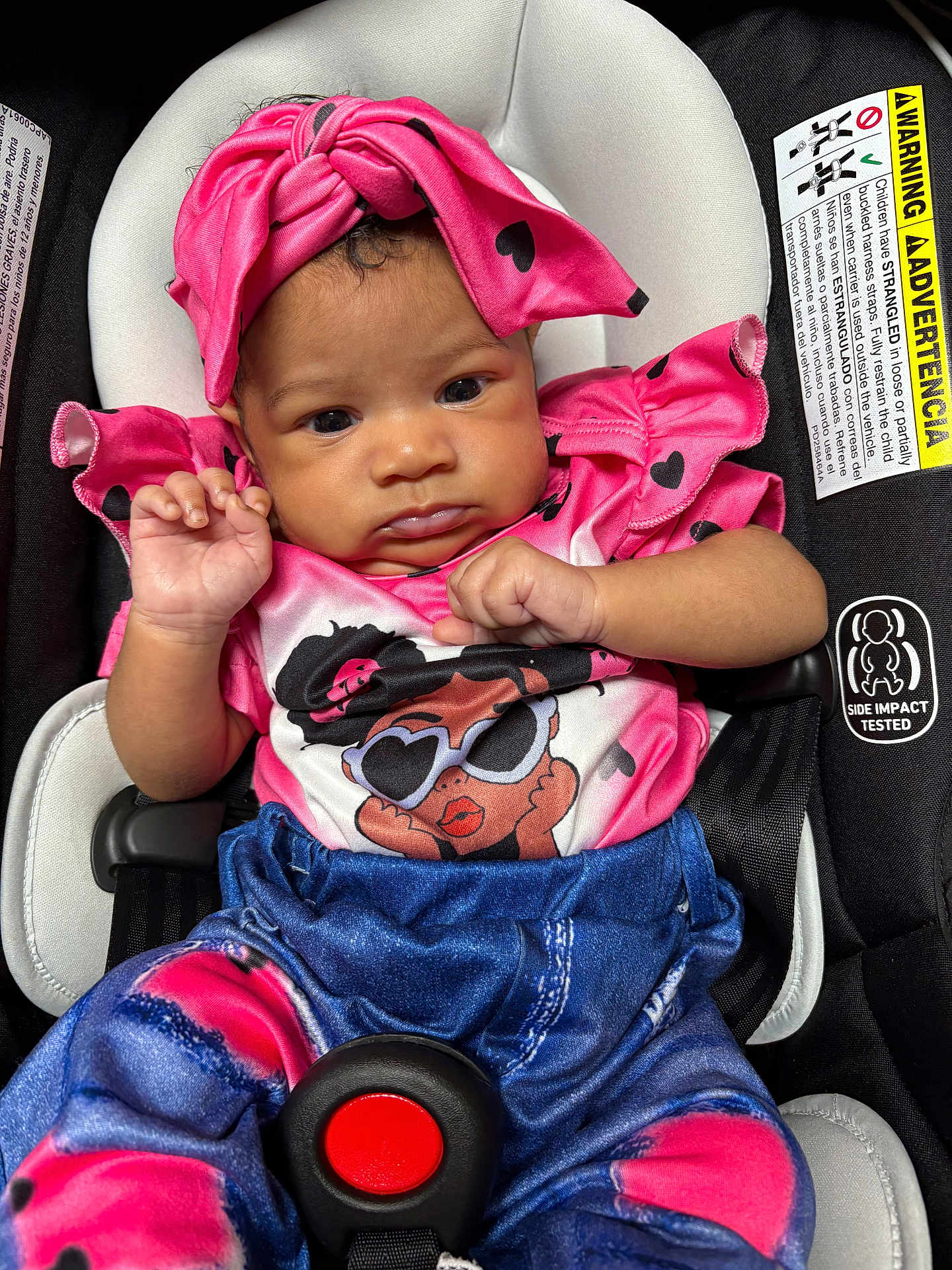 Journey joined the competition — help win amazing prizes! baby, child, car_seat, pink_clothing, headwrap, heart_pattern, infant, cute, portrait, strapped_in, seatbelt, denim_print, colorful, young_child, baby_girl, sitting, close_up, indoors, serious_expression, small_hands