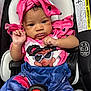Journey is registered to the contest to win money with this photo: baby, child, car_seat, pink_clothing, headwrap, heart_pattern, infant, cute, portrait, strapped_in, seatbelt, denim_print, colorful, young_child, baby_girl, sitting, close_up, indoors, serious_expression, small_hands
