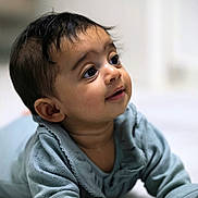 Christian is registered to the contest to win money with this photo: baby, infant, child, tummy, blue_clothing, curious, smile, indoors, soft_light, portrait, young_child, cute, skin, face, hands, expression, lying_down, short_hair, closeup, warm