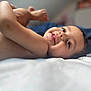 Maria participe au concours pour gagner de l'argent avec cette photo : child, toddler, smile, face, skin, bed, blanket, lying_down, happy, tongue_out, indoor, person, cute, infant, close_up, head, legs, bare_skin, relaxing, young