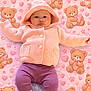 baby, infant, pink_hoodie, purple_pants, socks, blanket, teddy_bear_pattern, hearts, paw_prints, cute, cozy, child, portrait, laying_down, soft_texture, knitwear, adorable, sleepwear, warm_clothing, cute_pattern