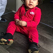 Jisslyn joined the competition — help win amazing prizes! child, toddler, baby, portrait, sitting, indoors, red_tracksuit, sneakers, pigtails, smiling, face, curly_hair, fashion, sportswear, floor, wooden_floor, home, doorway, shoes, nike