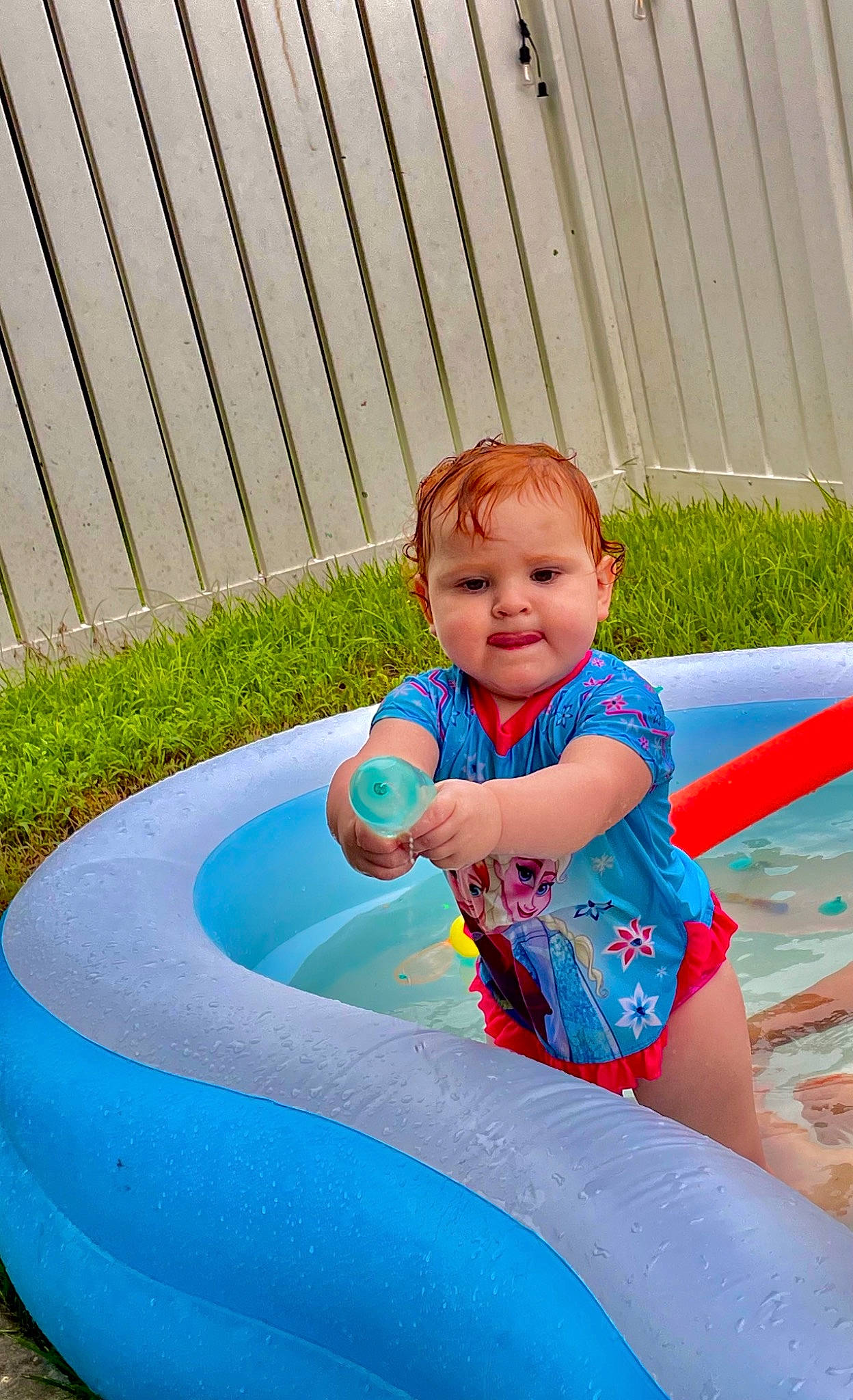 Julie is registered to the contest to win money with this photo: aqua, azure, baby, baby_toddler_clothing, child, electric_blue, fun, grass, happy, inflatable, leisure, outdoor_play_equipment, person, play, recreation, sitting, smile, t_shirt, toddler, vacation