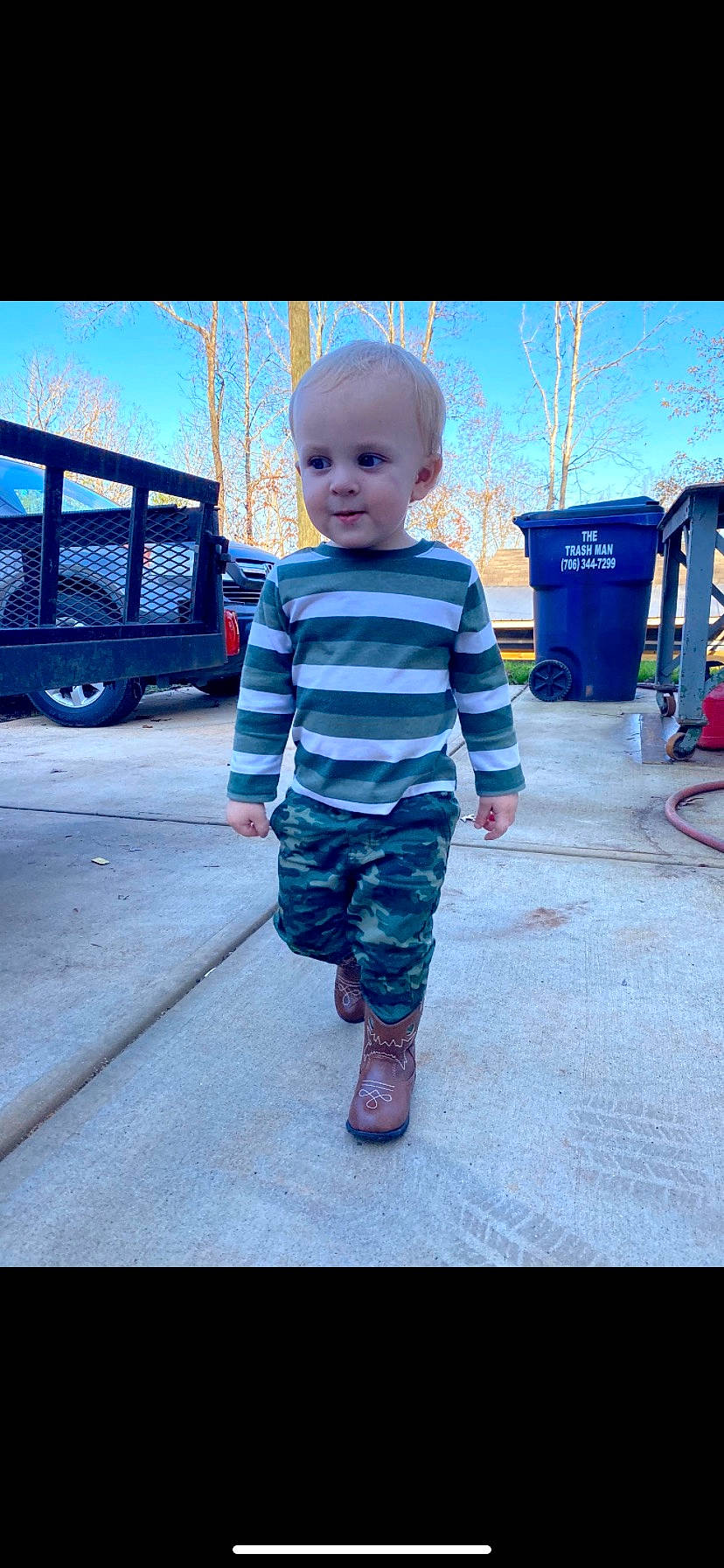 Levi is registered to the contest to win money with this photo: asphalt, baby, blue, cool, electric_blue, face, grass, happy, leisure, morning, person, photograph, recreation, sky, t_shirt, tints_and_shades, tire, toddler, travel, tree