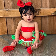 Evelyn is registered to the contest to win money with this photo: toddler, child, red_bow, tutu_skirt, red_booties, glass_table, wooden_fence, curly_hair, sitting, outdoor, festive_clothing, cute, portrait, baby, headband, colorful_clothing, young_child, curious_expression, casual_pose, daylight