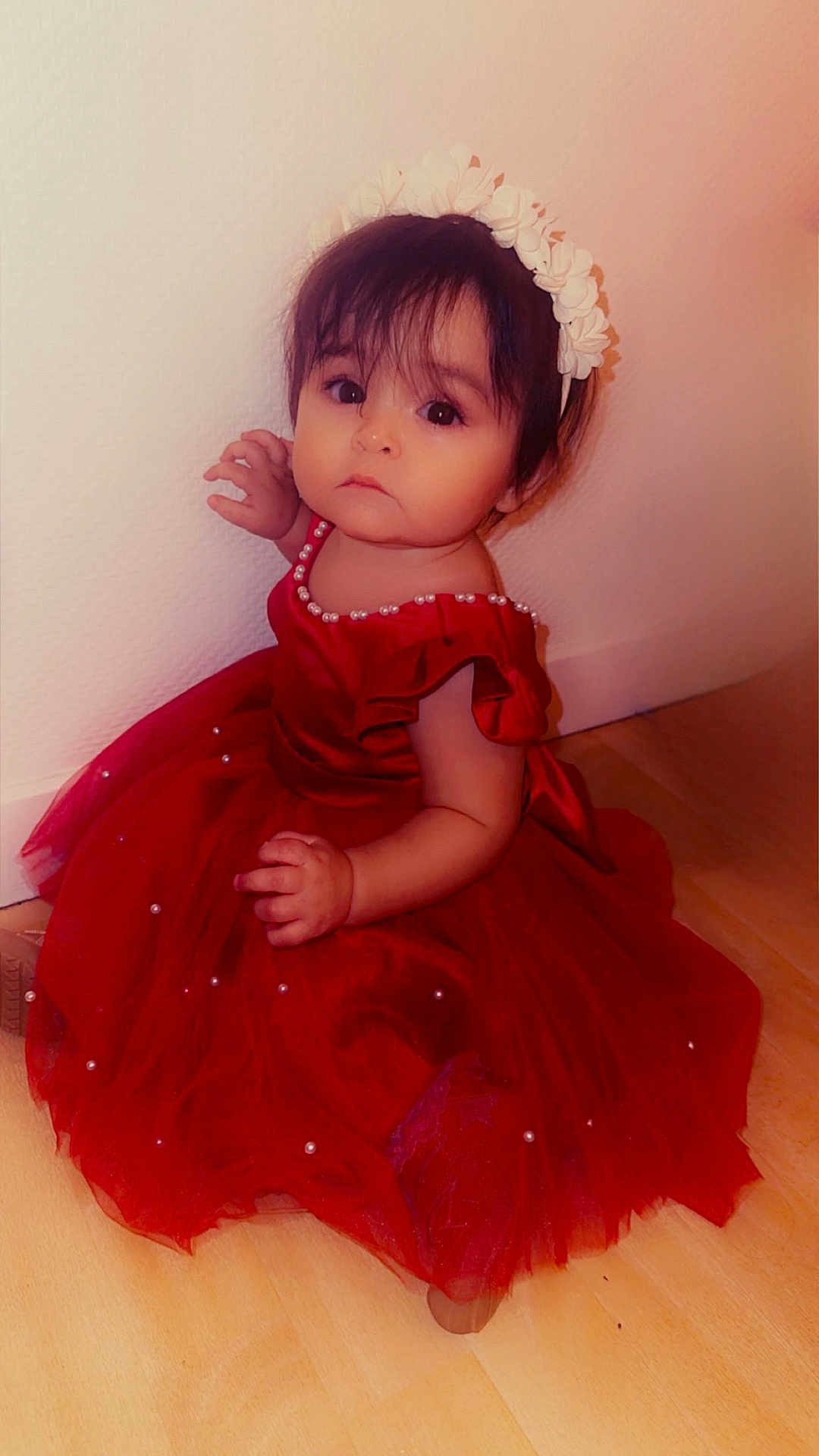 Sélia participe au concours pour gagner de l'argent avec cette photo : toddler, child, red_dress, headband, pearl_decoration, floor, wall, sitting, indoor, portrait, cute, young_child, long_hair, looking_at_camera, expression, fashion, person, baby, girl, clothing