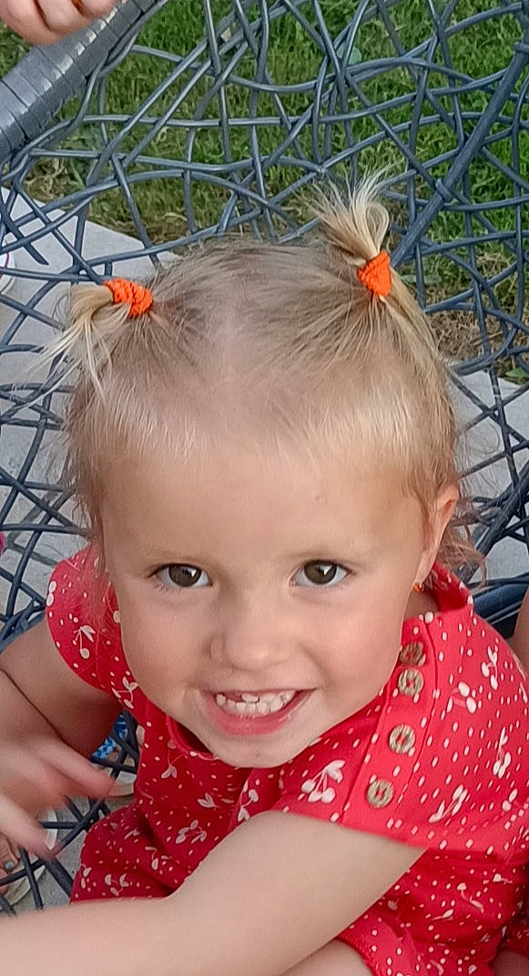 Soraya participe au concours pour gagner de l'argent avec cette photo : baby, baby_toddler_clothing, child, chin, fun, grass, hair, hair_tie, hairstyle, happy, head, headband, iris, joy, lip, person, pink, red, skin, smile