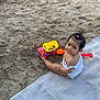Estella participe au concours pour gagner de l'argent avec cette photo : toddler, child, beach, sand, toy_truck, shovel, blanket, water, play, outdoor, summer, barefoot, cute, young_child, person, nature, recreation, vacation, sunhat, relaxation