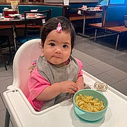 Estella a rejoint le concours — aidez-le/la à gagner de superbes lots ! toddler, child, high_chair, bowl, macaroni, pasta, bib, pink_shirt, hair_clip, restaurant, table, chair, floor, indoor, feeding, baby, cute, food, person, seat