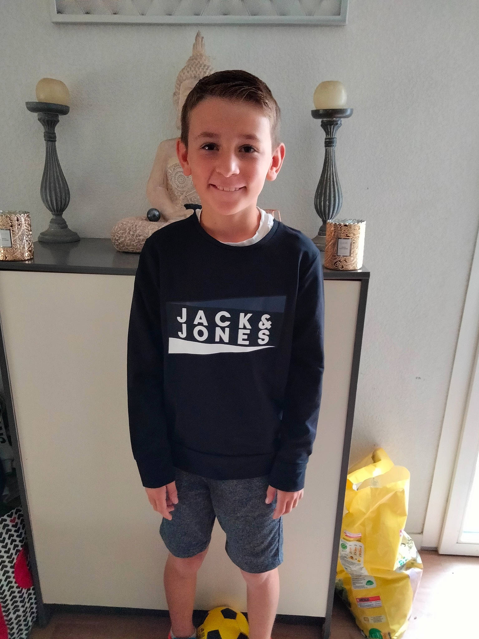 Tymothe participe au concours pour gagner de l'argent avec cette photo : black, box, child, electric_blue, eyewear, fashion_accessory, flooring, fun, joint, joy, knee, person, room, shorts, sitting, sleeve, sportswear, standing, t_shirt, toddler