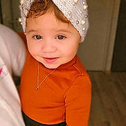 Mylena participe au concours pour gagner de l'argent avec cette photo : toddler, child, portrait, smile, headband, knitwear, pearls, brown_eyes, orange_clothing, necklace, indoor, person, cute, young_child, fashion, warm_colors, soft_lighting, happy, closeup, holding_hand