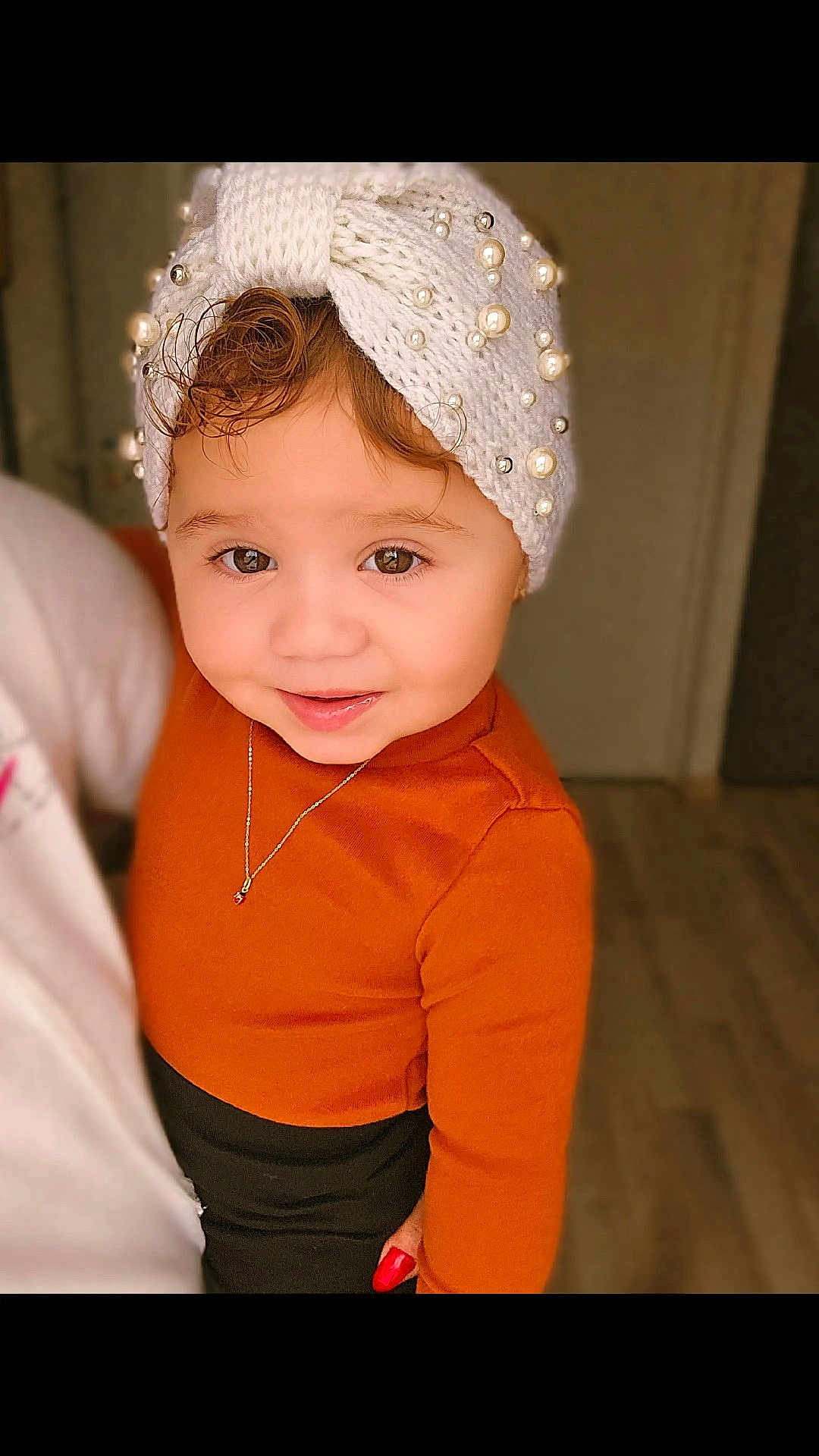 Mylena participe au concours pour gagner de l'argent avec cette photo : toddler, child, portrait, smile, headband, knitwear, pearls, brown_eyes, orange_clothing, necklace, indoor, person, cute, young_child, fashion, warm_colors, soft_lighting, happy, closeup, holding_hand