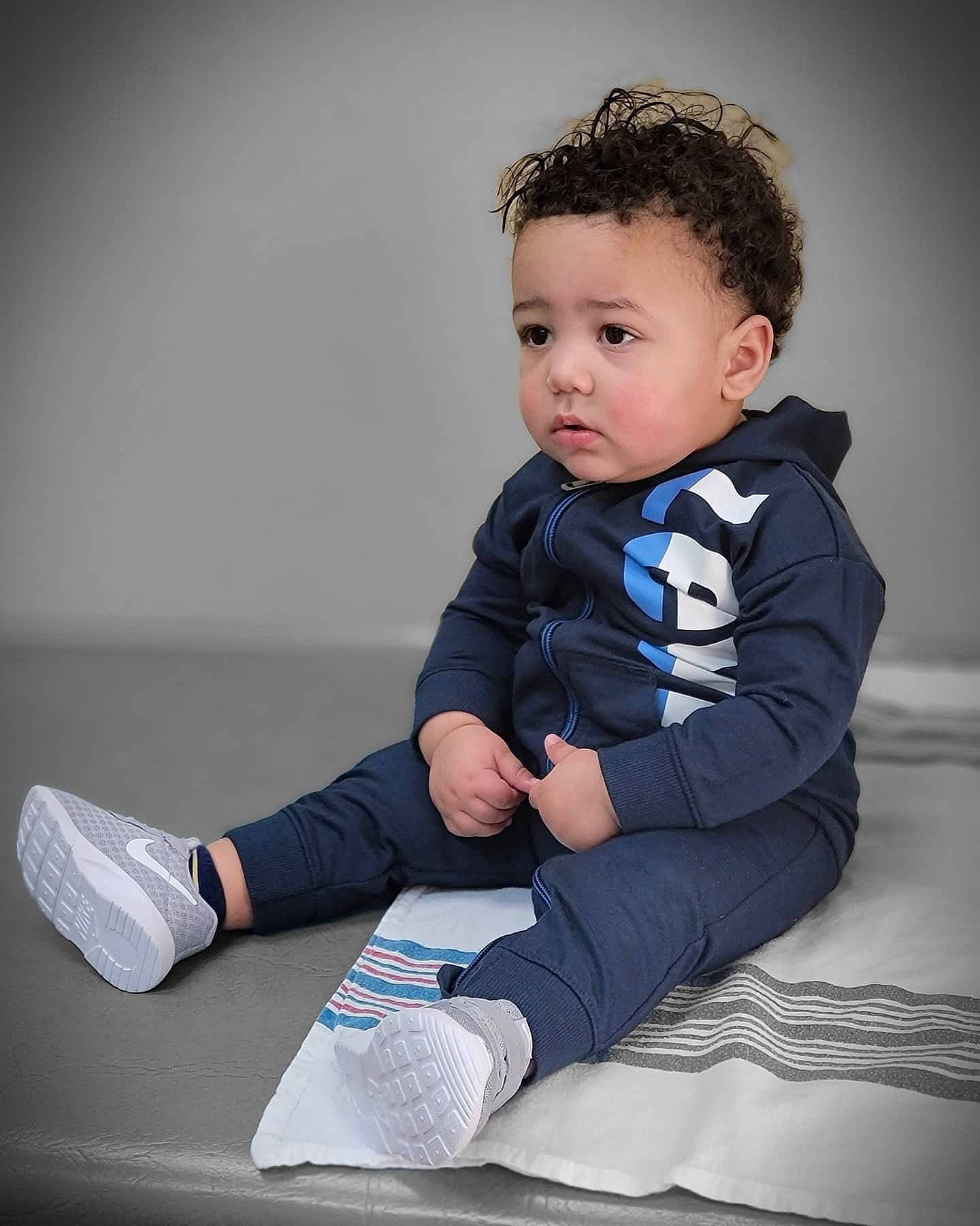 Arthur is registered to the contest to win money with this photo: baby, baby_toddler_clothing, cheek, collar, comfort, elbow, electric_blue, flash_photography, floor, flooring, happy, human_leg, knee, leg, person, shoulder, sitting, skin, sleeve, thigh