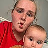 baby, brown_clothing, child, closeup, cute, eyes, face, family, freckles, head, home, indoor, infant, portrait, puckered_lips, red_shirt, selfie, smiling, wide_eyed, woman