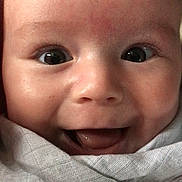 Lorenzo is registered to the contest to win money with this photo: baby, smiling, close_up, face, infant, eyes, blanket, happy, cute, child, skin, mouth, expression, portrait, newborn, young, person, head, wrapped, innocent