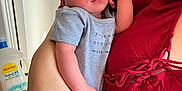Lorenzo joined the competition — help win amazing prizes! baby, newborn, sleeping, infant, person, hand, onesie, indoor, bathroom, sink, toilet, fabric, red_clothing, holding, skin, peaceful, resting, closeup, human, arm