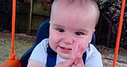 Lorenzo is registered to the contest to win money with this photo: baby, child, clapping, cute, fence, fun, garden, grass, happy, infant, nature, outdoor, person, play, seat, smile, summer, swing, toy, tree