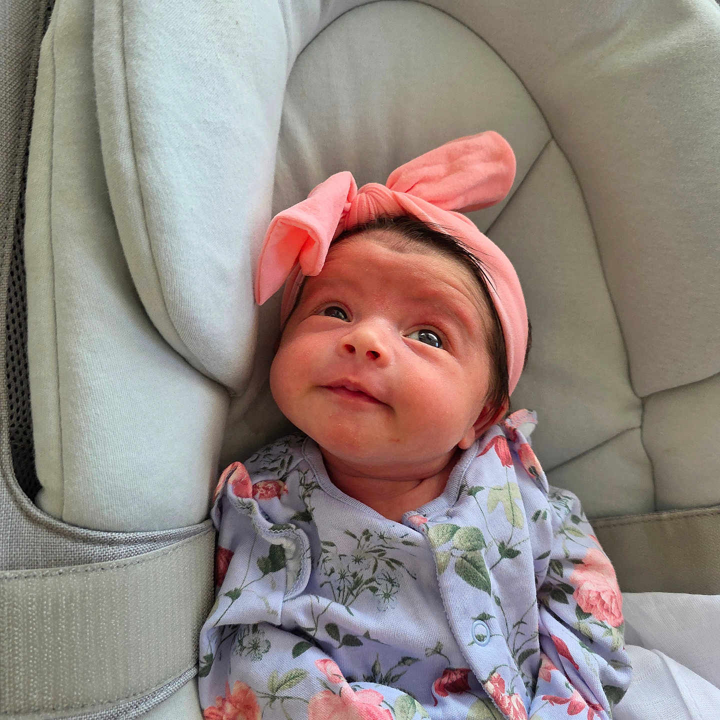 Raniyah is registered to the contest to win money with this photo: baby, child, closeup, comfort, curious_gaze, cushioned_seat, cute, expression, fabric, face, floral_onesie, headwear, indoors, infant, newborn, person, pink_headband, portrait, resting, soft_lighting