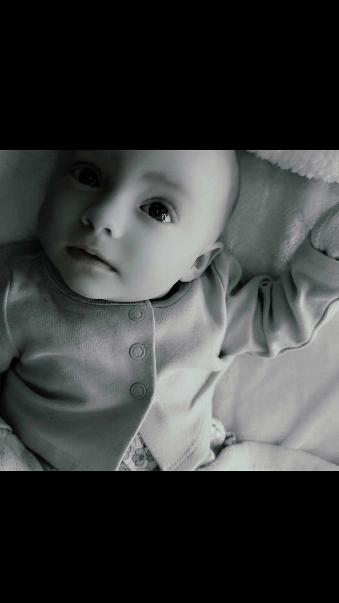 Octavia is registered to the contest to win money with this photo: baby, infant, child, portrait, face, eyes, onesie, buttons, blanket, soft_texture, lying_down, close_up, monochrome, black_and_white, innocence, cute, small_person, bed, pillow, gaze