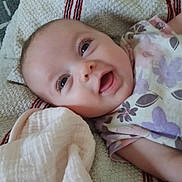 Eliana joined the competition — help win amazing prizes! baby, smiling, infant, blanket, clothing, face, person, textile, happy, cute, lying_down, soft, child, portrait, closeup, newborn, sleepwear, fabric, resting, toddler