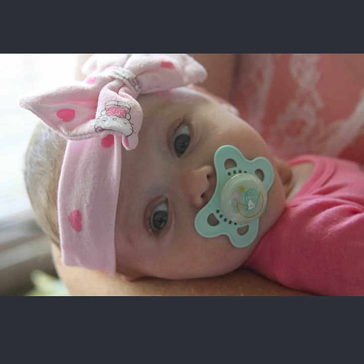 Eliana is registered to the contest to win money with this photo: adorable, baby, baby_girl, child, closeup, clothing, cute, eyes, face, headband, headwear, indoors, infant, looking, pacifier, pink, portrait, resting, soft, young