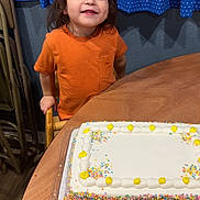 Kosei joined the competition — help win amazing prizes! birthday_cake, blue_curtains, cake, celebration, chair, child, confetti, food, furniture, happy, icing, indoor, orange_shirt, patterned_curtains, person, smiling, table, toddler, wooden_table, yellow_icing