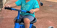 Kosei joined the competition — help win amazing prizes! toddler, child, tricycle, outdoor, curly_hair, barefoot, blue_tricycle, turquoise_shirt, shorts, concrete_driveway, grass, sunny, greenery, person, play, summer, casual_clothing, daylight, small_vehicle, cute