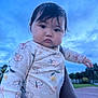 baby, child, infant, face, portrait, outdoor, sky, clouds, onesie, flower_pattern, butterfly_pattern, cute, holding, person, young, expression, soft_lighting, nature, grass, hand